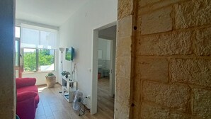Un salón moderno con un sofá rojo, un ventanal grande y vistas a zonas verdes.