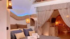 A cozy bedroom with a bed, pillows, a bedside table, and a lamp.