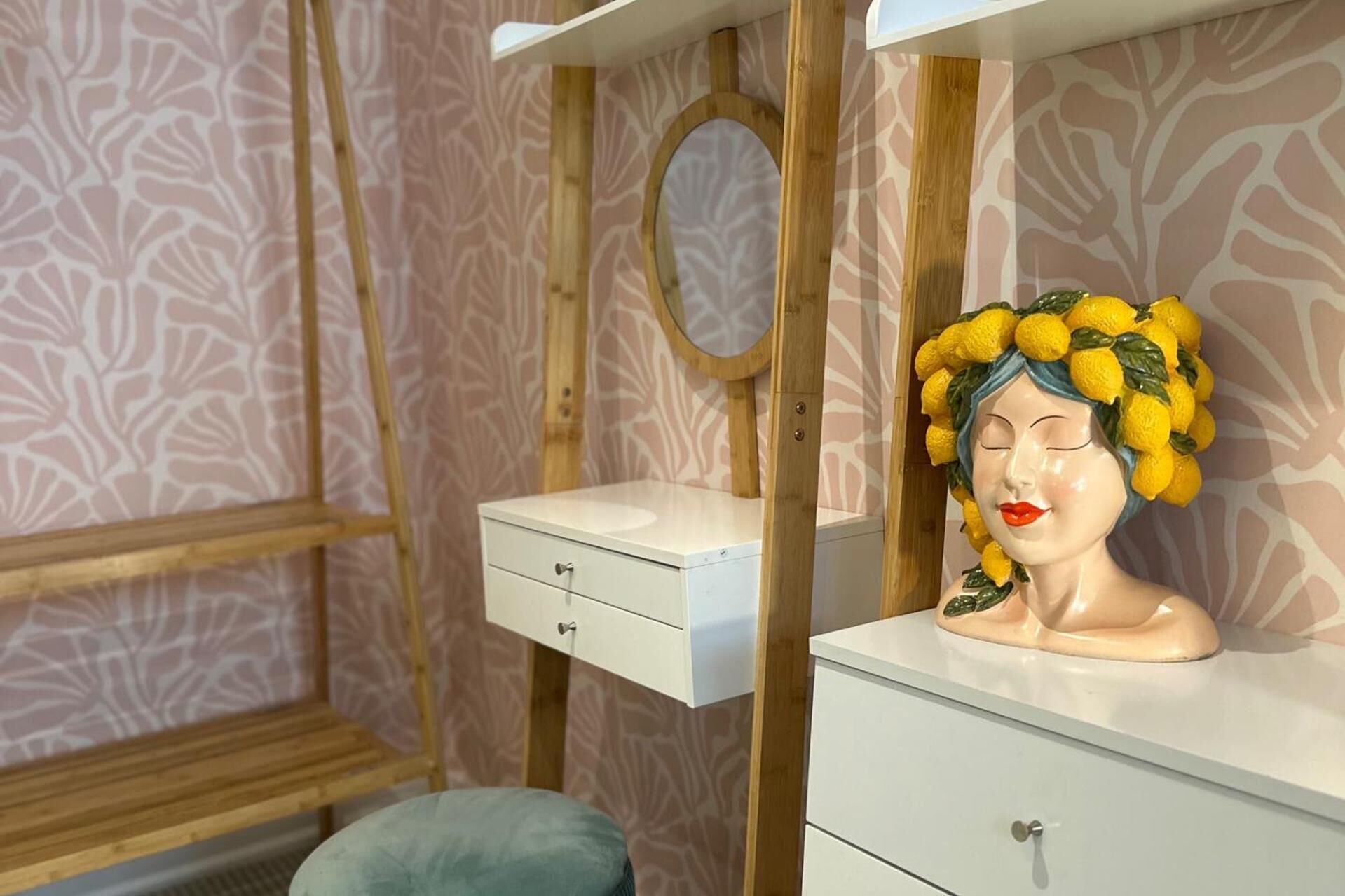 A bathroom with a vanity, a mirror, and a decorative bust.
