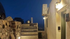 A stone staircase leading to a building entrance at dusk. - Bluegonia. (Έξω Γωνιά)