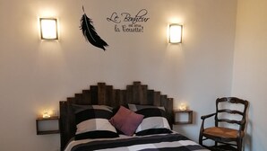 A bedroom with a bed, a wall-mounted feather decoration, and two wall sconces. - Maison LA Longe'yeres (Saint-Martin-le-Gaillard)