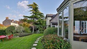 A well-maintained garden with a stone path leading to a seating area. - Le Cottage de La Maison Saint Léonard | Lovely Shared Garden in the Heart o (Honfleur)