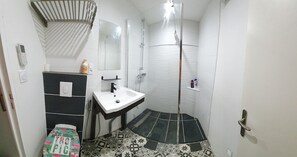 Een douche, handdoeken, zeep, toiletpapier