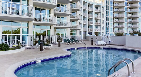 Relax by the rooftop pool surrounded by a balcony with a view.