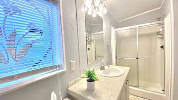 Bañera con ducha, toallas, jabón, shampoo