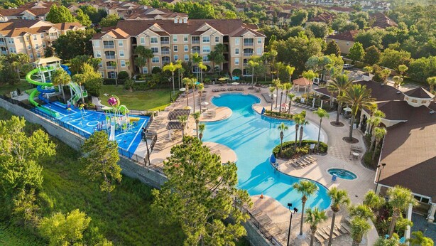 A resort with a large pool, a water park, and multiple buildings with balconies.