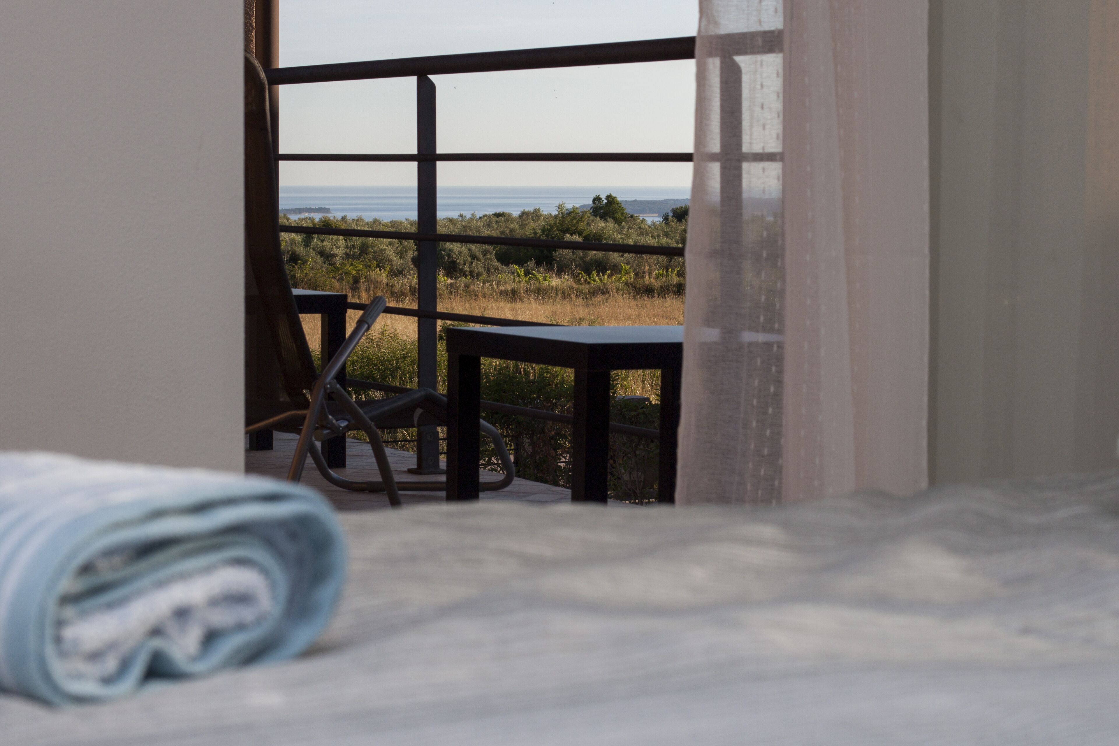 Una habitación con vistas al mar, una cama, una silla y una mesa.
