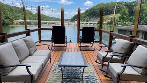 A deck with a sofa, two chairs, a table, and a patterned rug. - Welcome to Our Little Slice of Heaven on the Lake! (Lake Lure)