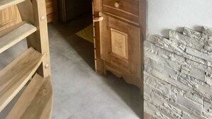 Pesuhuone, jossa on pesukone, kuivausrumpu ja puinen kaappi laatikoineen.