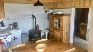 Kompakti keittiö, jossa on puuhella, mikroaaltouuni ja puinen kaappi.