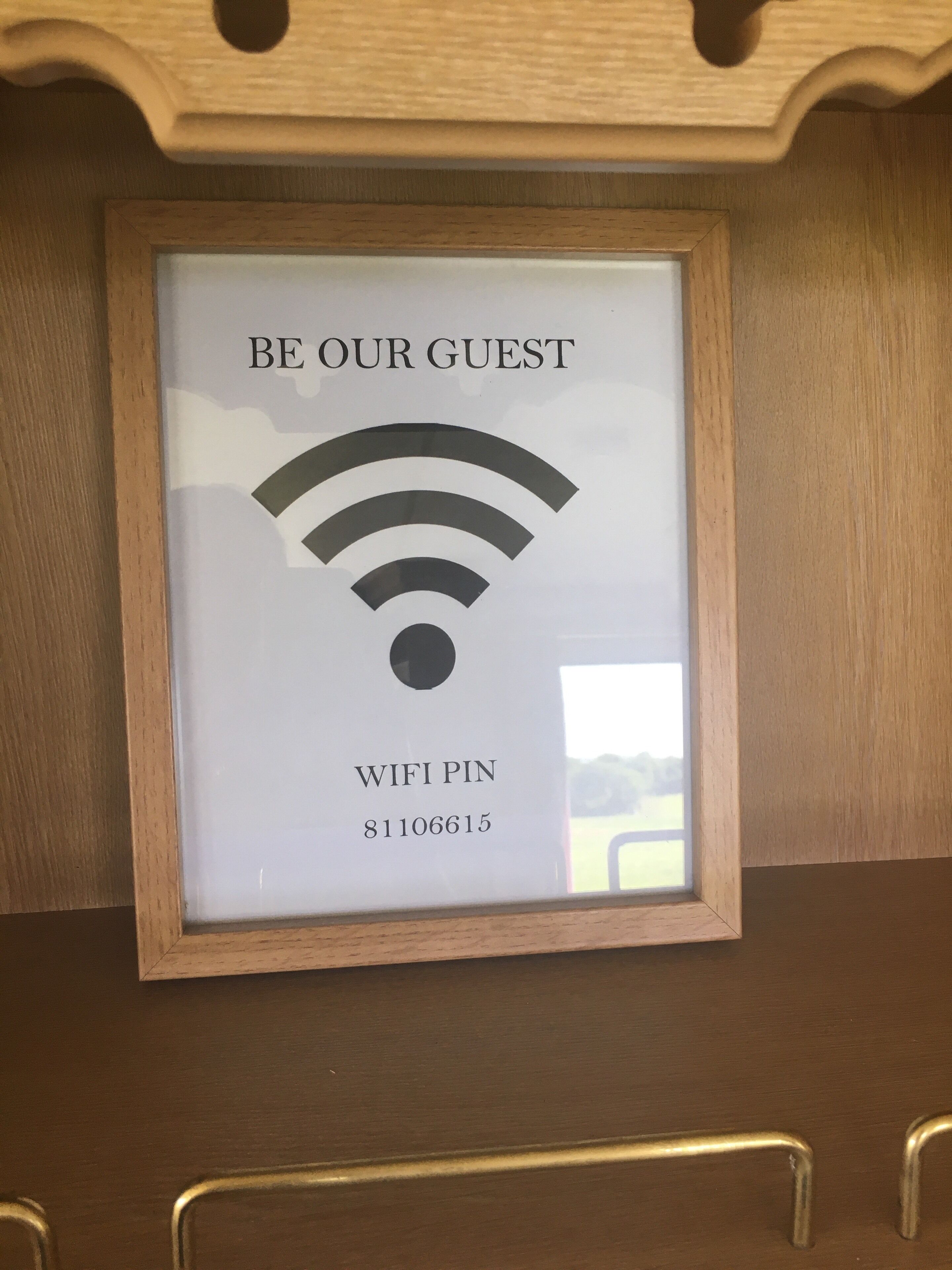 Une pancarte encadrée avec le symbole du Wi-Fi et les inscriptions « SOYEZ LES BIENVENUS » et « CODE WI-FI : 81106615 ».