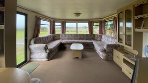 Una sala de estar con un sofá modular, una mesita y un mueble.