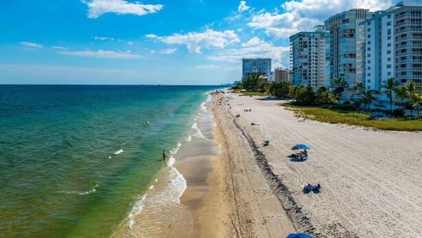 A beach with a row of high-rise buildings, clear blue sky, and calm sea. - Apt#1-Charming relaxing -beautiful APT-80yard walk to the BEACH wBBQ/ Patio (Pompano Beach)
