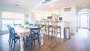 A bright kitchen with white cabinets, a central island, and a sign for 'Beach Therapy'. - Stunning Harbor Views! Boat Slip, 2 King Bedrooms, (Carolina Beach)