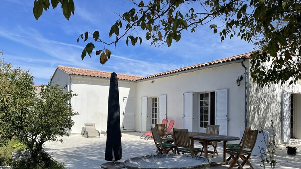 A courtyard with a dining table, chairs, and a birdbath. - Pretty house in a large garden / town center,  (La Flotte)