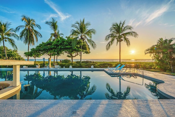 Olympic size outdoor pool with swim up bar, chaise lounges and tables.