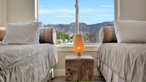A bedroom with two beds, a nightstand, and a view of mountains. - Entrada at Moab 598 and 602 | Townies | Pool/Spa | Garage | Same Day Booking (Moab)