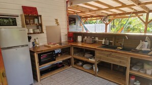 A compact kitchen with a refrigerator, microwave, and wooden countertop.