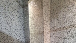A bathroom with mosaic tile walls and a glass shower enclosure. - Apparemment Agréable Idéal Pour Famille (Agadir)