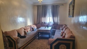 A living room with a sofa set, a coffee table, and a decorative cabinet. - Apparemment Agréable Idéal Pour Famille (Agadir)