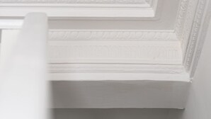 Un detalle arquitectónico blanco con una sección hundida y un repisa plana.