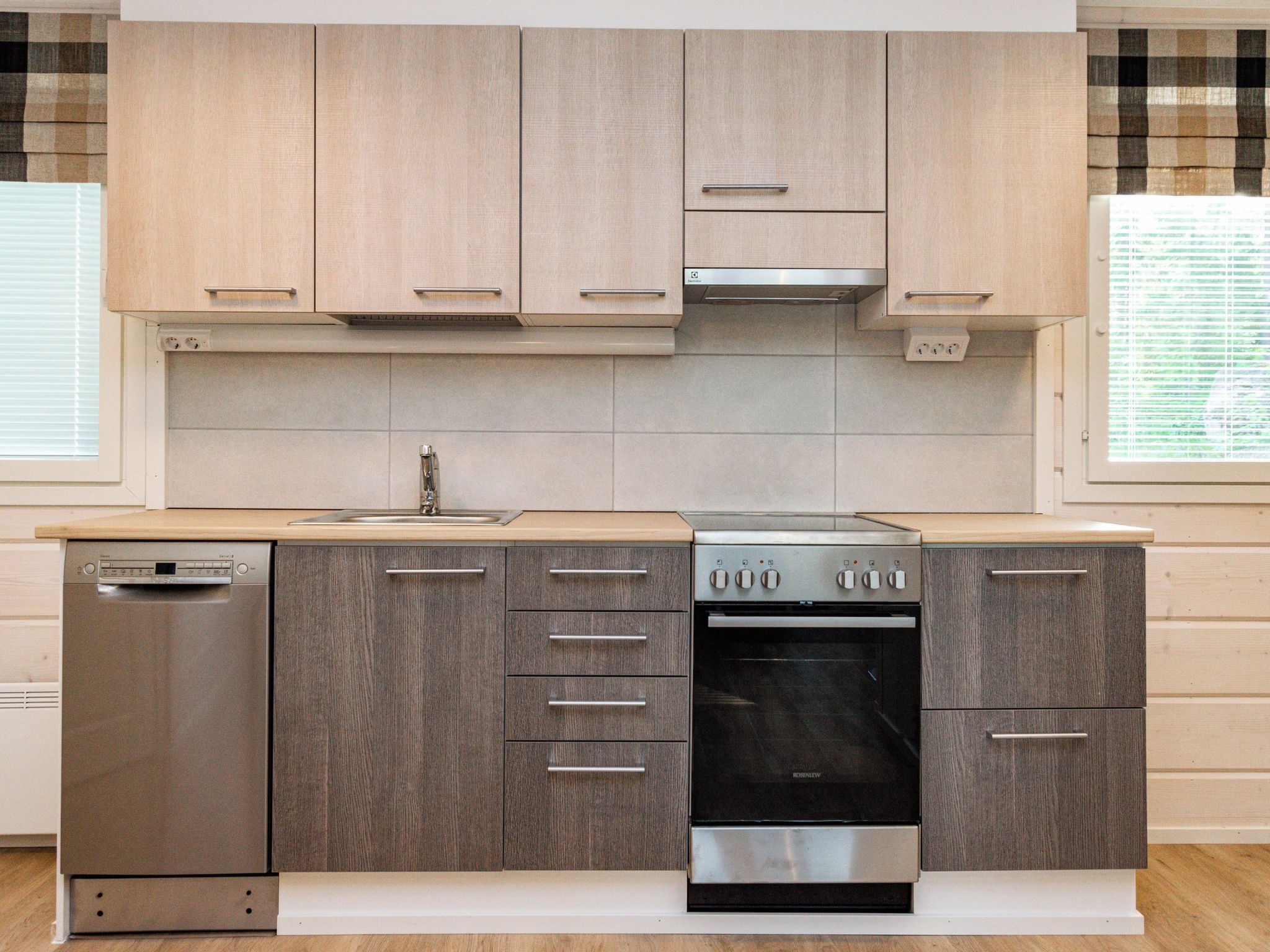 Una cocina moderna con lavavajillas, horno y campana extractora.