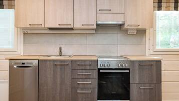 Una cocina moderna con lavavajillas, horno y campana extractora.