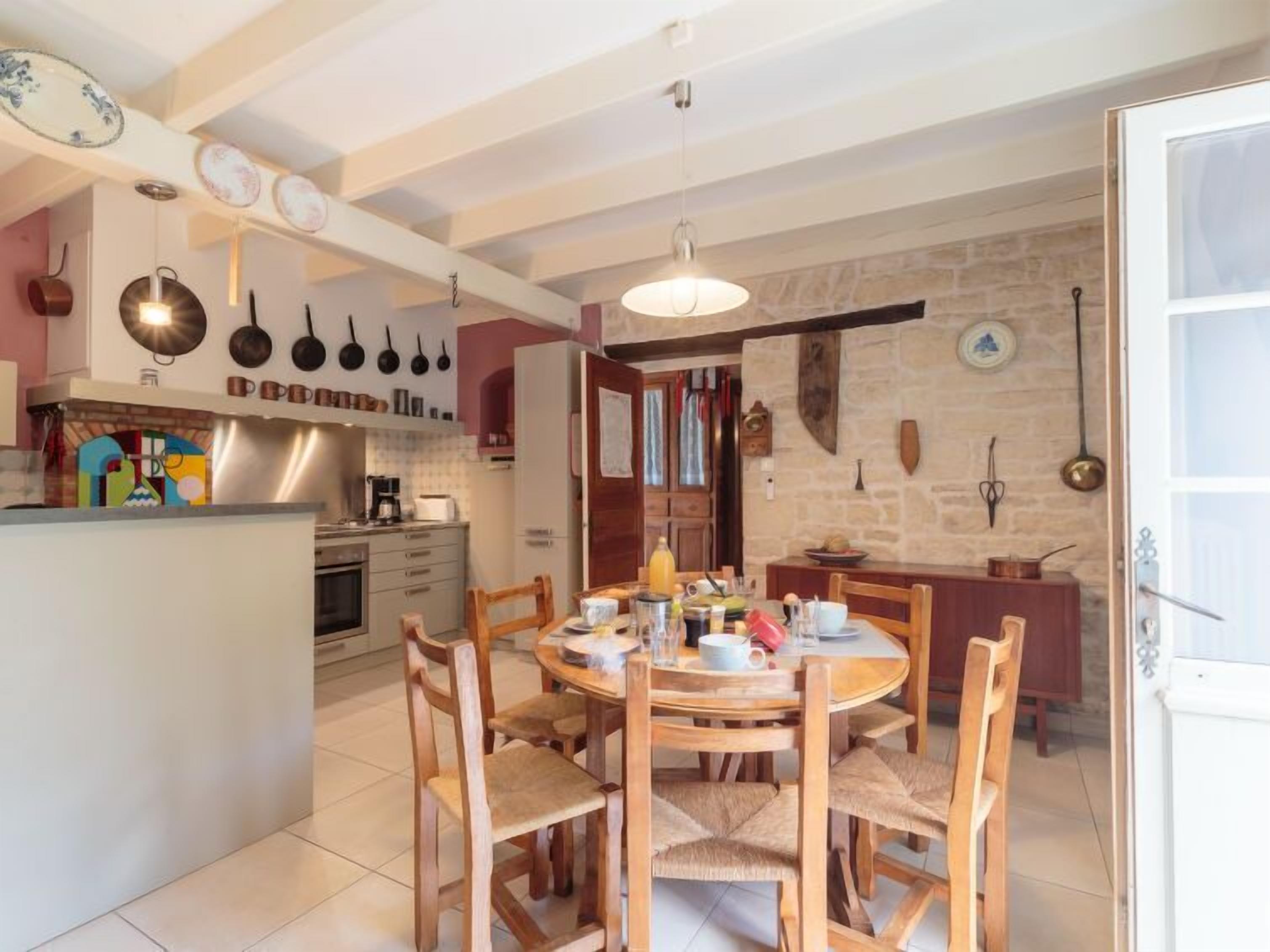 Una cocina con una isla central, sillas de madera y una mesa de comedor.