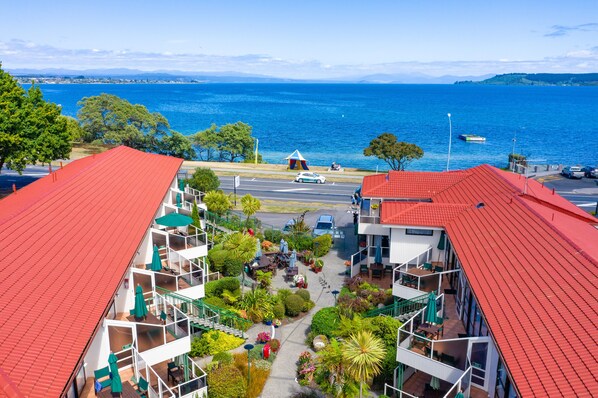 Un hôtel situé sur la côte, avec des toits rouges, des balcons et une vue sur la mer.