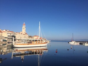 A boat docked at a harbor with a church and buildings in the background.