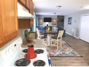 Cozy kitchen with a stove, dining area, and comfortable seating.