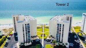 Vista di due edifici residenziali bianchi, con spiaggia e oceano sullo sfondo.