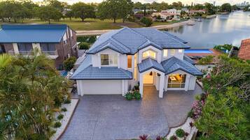 A two-story house with a grey tiled roof, a garage, and a driveway.