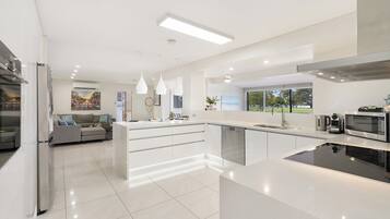 A modern kitchen with a central island, built-in appliances, and pendant lighting.