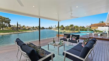 A poolside area with outdoor seating and a view of a large swimming pool.