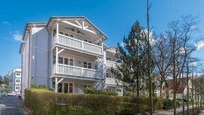 A multi-story building with balconies, a cobblestone street, and a clear blue sky. - Resid. Prorer Wiek App. 7, Strandnah in Binz, mit Balkon - App. mit 1 SZ + 1 Schlafkoje - Aufbettung (Binz)