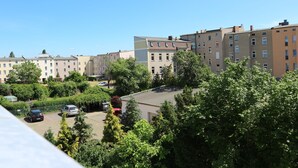 A residential area with multi-story apartment buildings, a parking lot, and lush greenery.