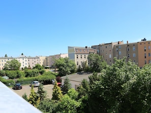 Un barrio residencial con edificios de apartamentos de varios pisos, un estacionamiento y abundante vegetación.