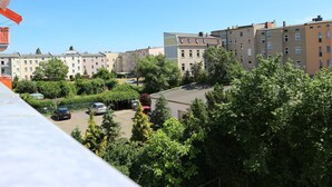 A residential area with multi-story buildings, a parking lot, and lush greenery.