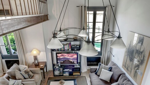 A spacious living area with a high ceiling, a staircase, and a view of the outdoors. - Beautiful Loft Apartement, quiet, 5 mn historical center (Isle sur la Sorgue)