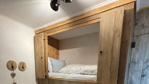 A bunk bed with a wooden ladder, a white wall with a wall clock, and a wooden floor. - Your own home in the Sauerland, relax if you can! (Willingen)