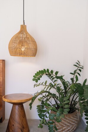 A room with a woven pendant light, a wooden table, and a woven plant pot. - Villa Ziggy (Canggu)