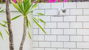 A white brick wall with a metal faucet and a keyhole.