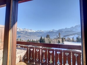 A balcony with a wooden railing and heart-shaped cutouts, overlooking a snowy mountain range and a clear blue sky. - 2 rooms + mezzanine at the foot of Combloux slopes (Combloux)