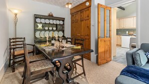 A dining area with a wooden table, chairs, and a china cabinet. - The Hollies - Short Walk to Beach Peaceful Location Parking (Narberth)