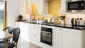 Une cuisine moderne avec des meubles blancs, un plan de travail noir et des appareils en acier inoxydable.