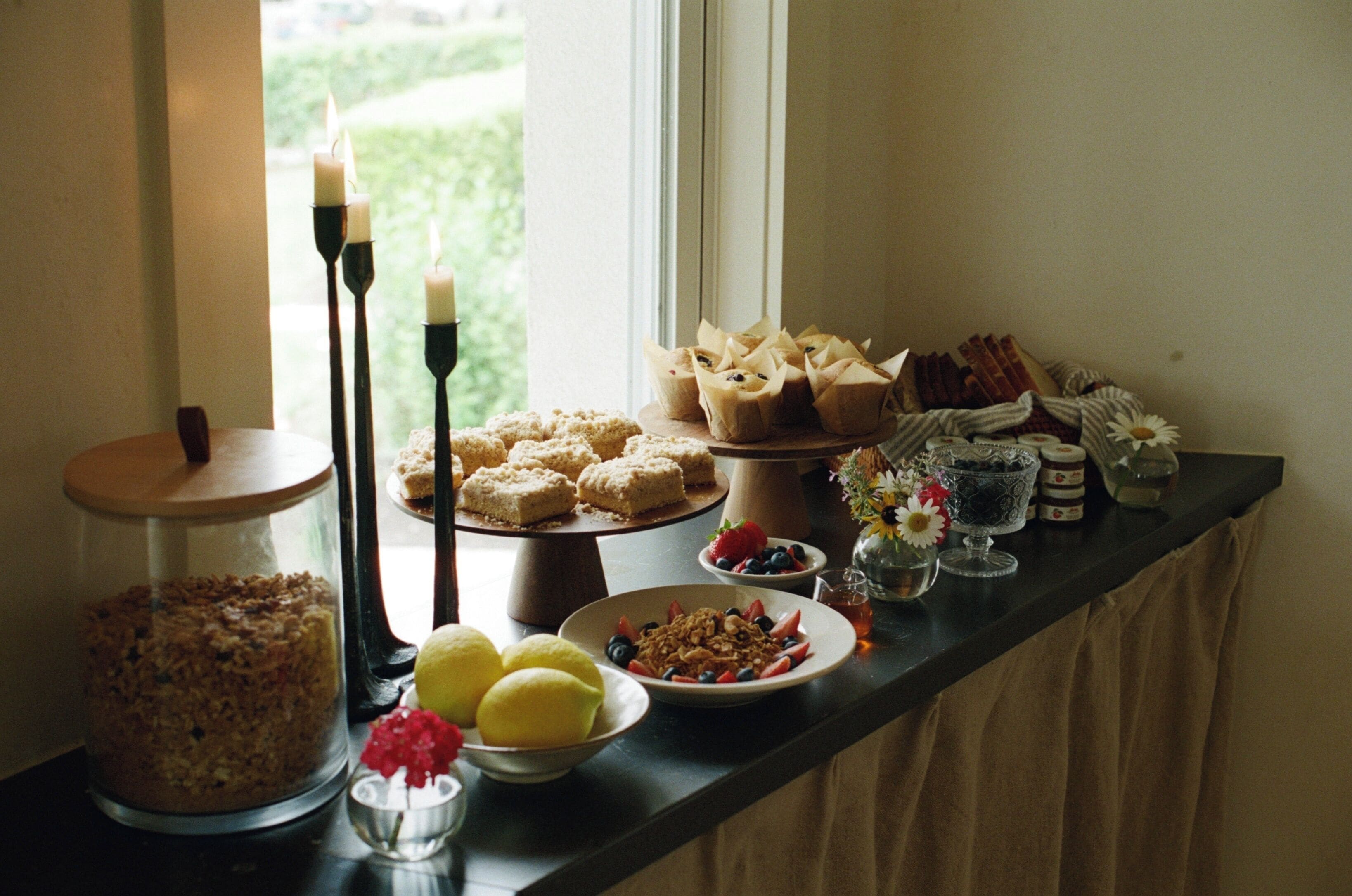 A buffet table with various food items and a candle holder.