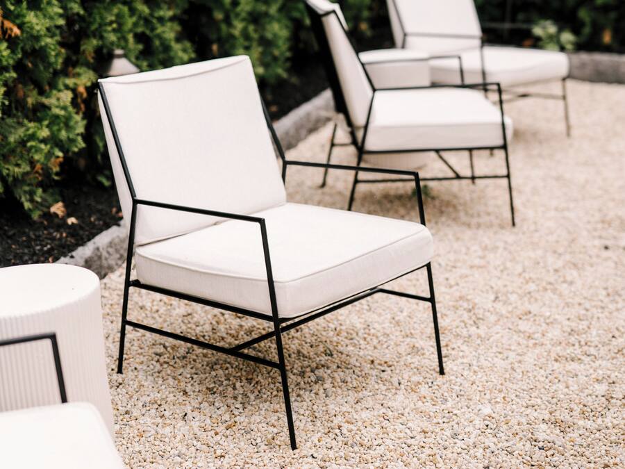 Terraza al aire libre con suelo de grava, rodeada de setos bien cuidados.
