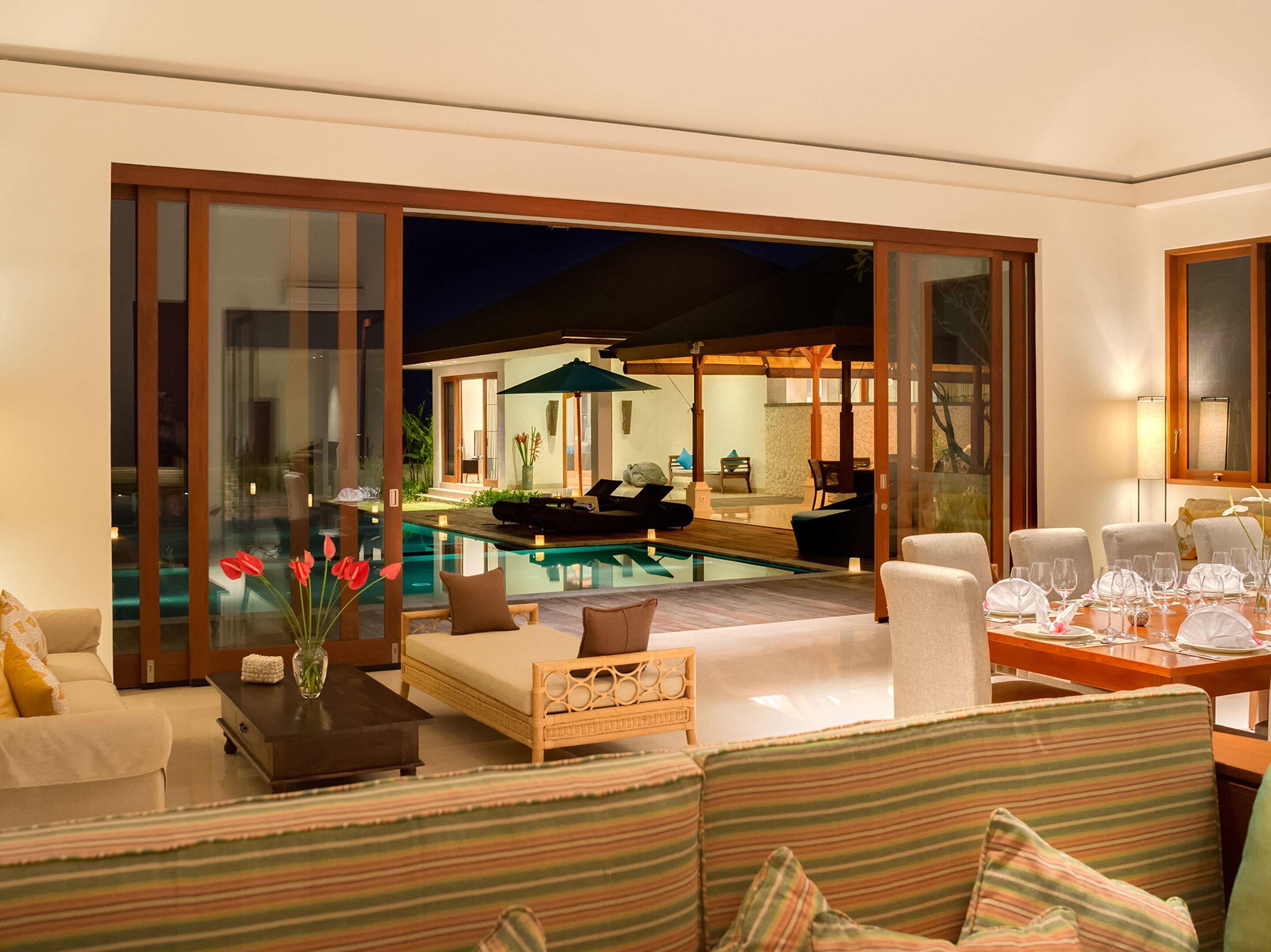 A modern living room with a pool, comfortable seating, and a dining area.