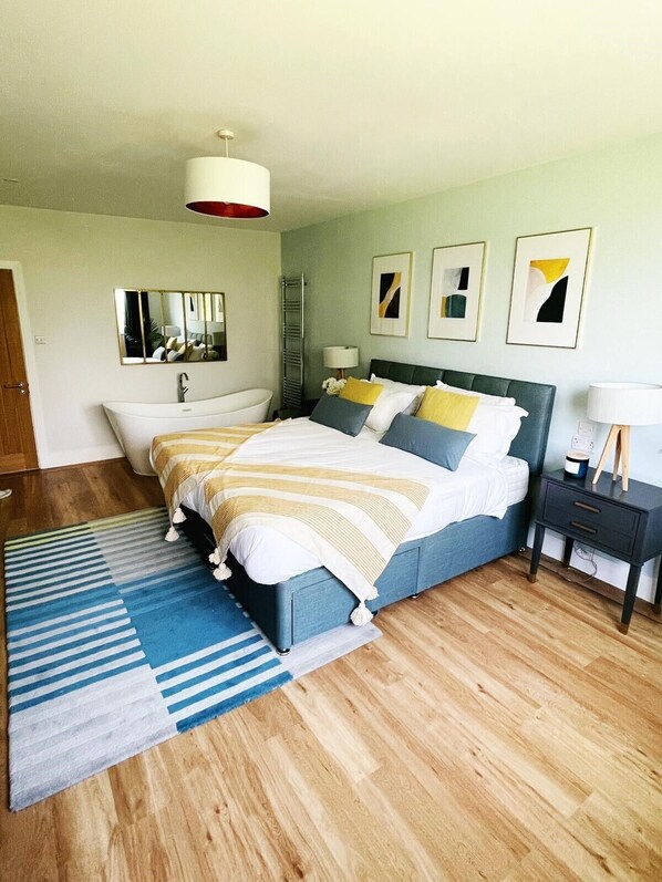 Une chambre à coucher moderne avec un lit, une table de chevet et un miroir.